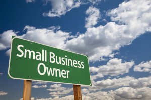 Small Business Owner Green Road Sign with Dramatic Clouds and Sky.